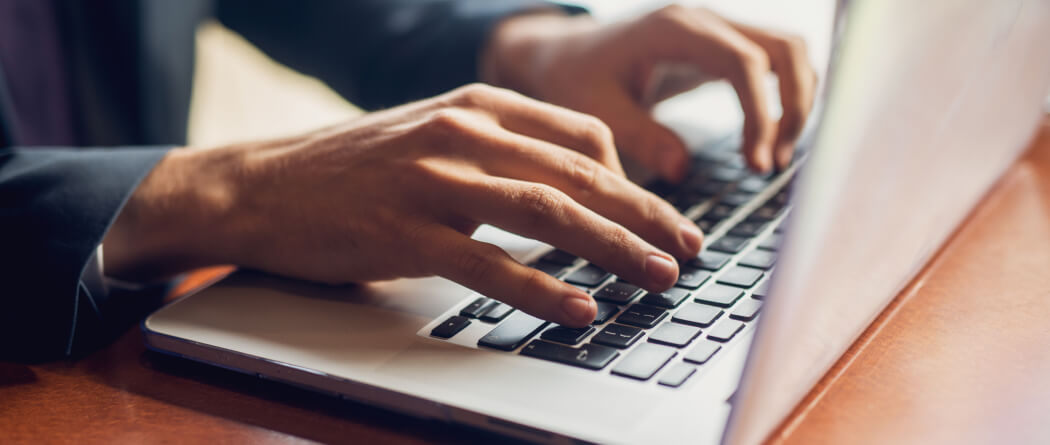 Man typing on laptop keyboard