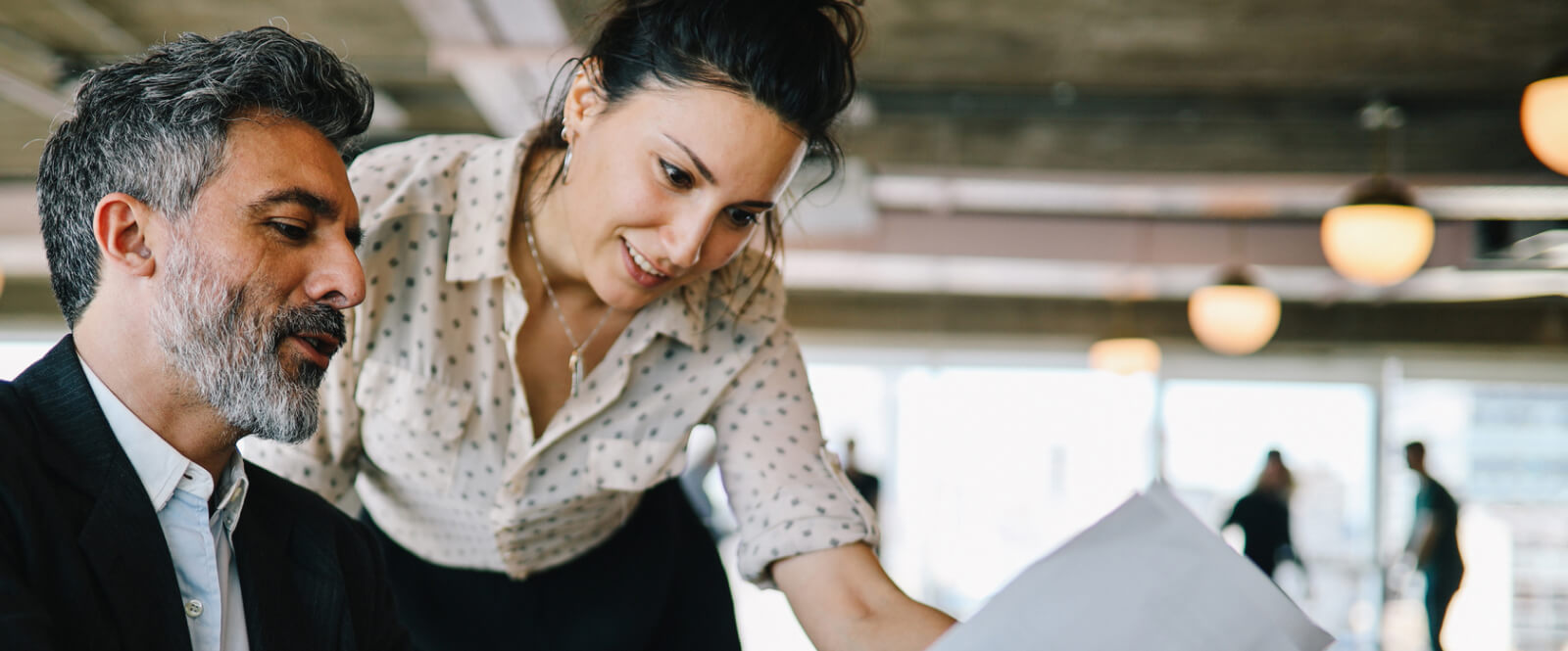 Business woman and man looking at a document together.