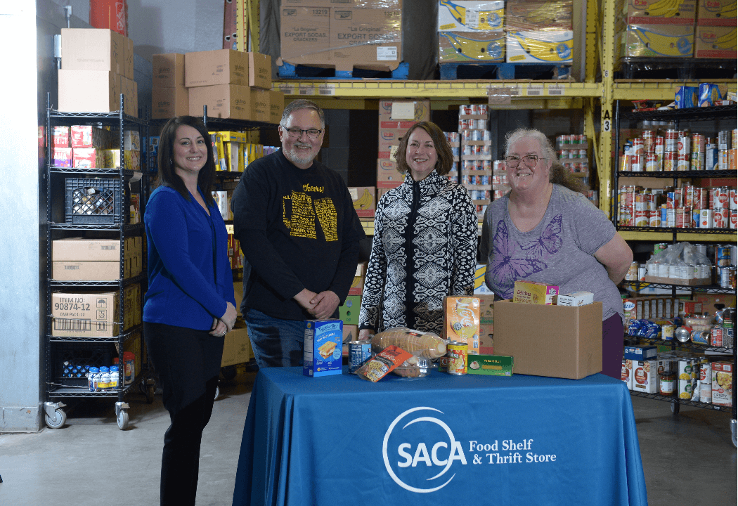 Group of four people smiling at a food shelf.
