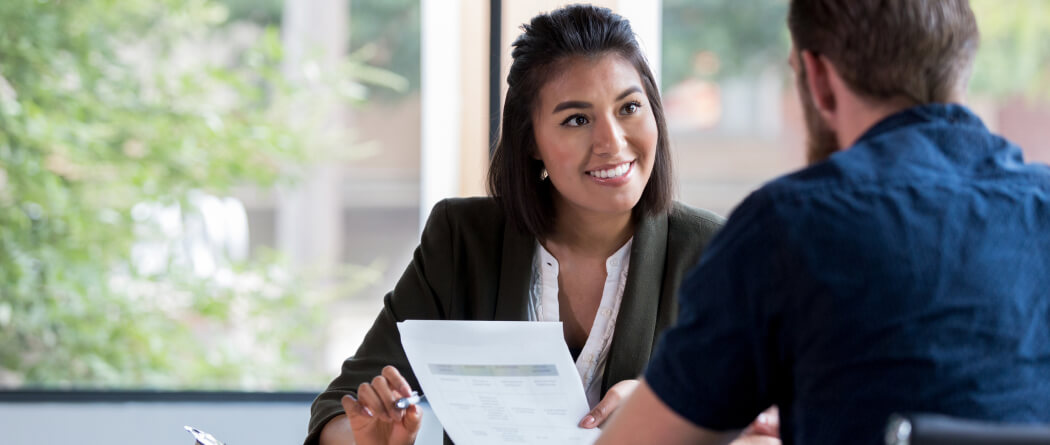 Man and woman having a discussion while looking at documents