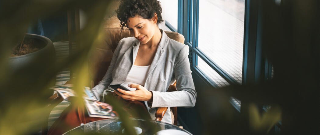 Woman lounging in a chair using mobile phone